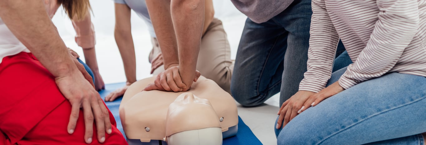 A man performing compressions on a CPR dummy