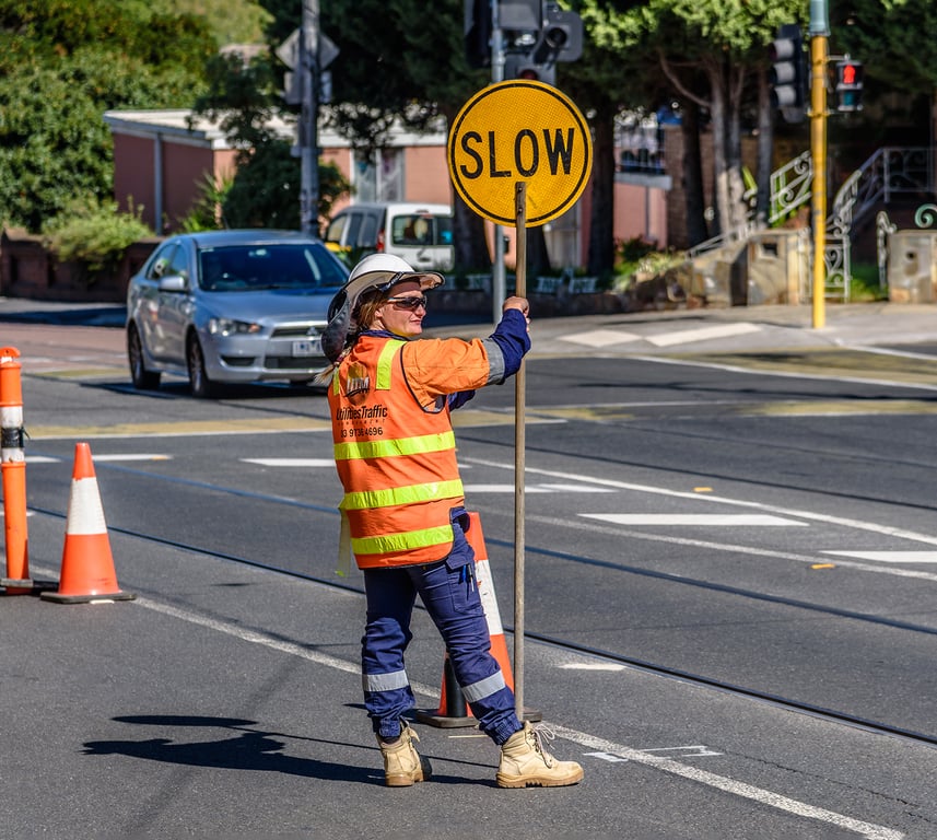 A traffic controller holding a stop-slow bat