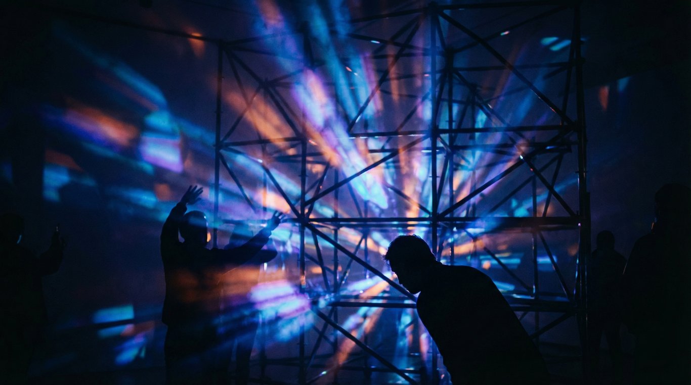 Installation immersive avec lasers rouges et fumée dans un entrepôt industriel