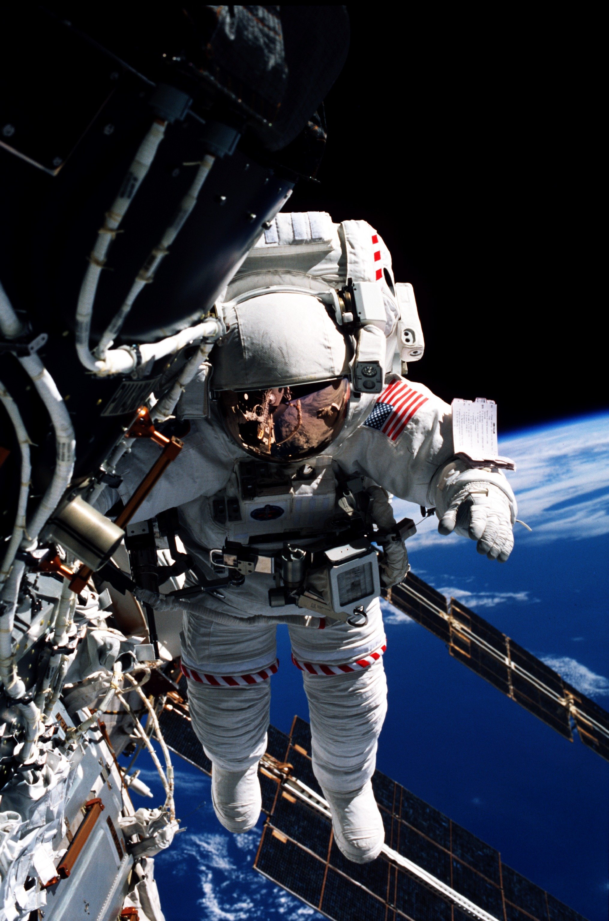 An astronaut on a spacewalk in a gas-pressurized suit