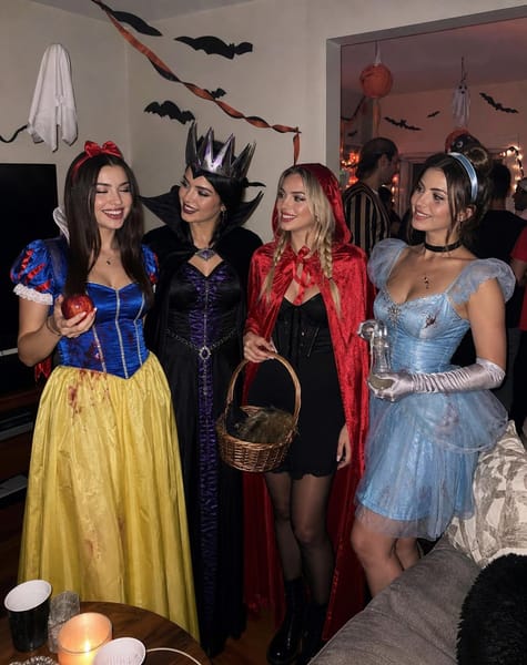 Create ONE ultra-photorealistic, candid iPhone photograph of the SAME four adult women from the uploaded reference group photograph, attending a casual Halloween house party. Each woman is dressed as a different, instantly recognizable fairytale character reimagined as a creepy Halloween costume: Snow White, the Evil Queen, Red Riding Hood, and Cinderella.
The final image must look like a real photograph taken spontaneously by a friend at an ordinary house party. It must NOT look like an AI-generated image, professional fashion campaign, fantasy illustration, movie poster, or staged costume photoshoot.
IDENTITY PRESERVATION — ABSOLUTE PRIORITY
Preserve the recognizable facial identity of all four women from the supplied group reference, maintaining their original left-to-right identity mapping.
* Woman 1 in the reference becomes Snow White.
* Woman 2 becomes the Evil Queen.
* Woman 3 becomes Red Riding Hood.
* Woman 4 becomes Cinderella.
The reference image is for identity only. Do not copy the original clothing, outfits, accessories, hairstyles, makeup, poses, body positions, background, lighting, or composition.
Reconstruct each woman’s face naturally within the new photograph. Preserve her distinctive facial structure, eyes, nose, lips, natural skin tone, and recognizable features. Match facial lighting, perspective, shadows, and skin texture to the new environment. Faces must look genuinely photographed in the scene, with visible natural pores and subtle imperfections.
Absolutely no pasted-on faces, face cutouts, mismatched skin tones, artificial smoothing, identity swapping, or blending facial features between people.
FOUR DISTINCT HALLOWEEN COSTUMES
WOMAN 1 — SNOW WHITE, THE HAUNTED PRINCESS
Give her a recognizable Snow White-inspired costume with a royal-blue bodice, puffed blue-and-red sleeves, a yellow skirt, a red hair bow, and a small red apple prop. The outfit must look like a real, wearable Halloween fancy-dress costume made from fabric, not an animated princess dress. Add darkened eyes, slightly smudged eyeliner, deep red lips, and a subtle eerie doll-like expression. Keep her hairstyle recognizable as a Snow White-inspired look without copying her original reference hairstyle.
WOMAN 2 — THE EVIL QUEEN
Dress her in a dramatic black-and-deep-purple costume with structured shoulders, a dark velvet-like cape, a tall pointed crown, and silver or dark metallic details. Add dark smoky eyes, sharply defined brows, deep burgundy lips, and a sinister but natural expression. The crown must look like a real costume accessory. Her silhouette should be visibly different from Snow White’s.
WOMAN 3 — LITTLE RED RIDING HOOD, HORROR EDITION
Give her a vivid red hooded cape over a short black dress, dark tights, black ankle boots, and a small woven basket containing a few believable Halloween props. Add smudged eye makeup, a subtle fake-blood mark on the cape, and slightly messy braided hair. Make her look like a dark fairytale character at a Halloween party, not a generic witch.
WOMAN 4 — CINDERELLA AFTER MIDNIGHT
Dress her in a recognizable pale-blue Cinderella-inspired ball-gown costume with a fitted bodice, a short layered tulle skirt, silver accessories, delicate gloves, and a black choker or dark ribbon. Add subtle cracked-doll makeup around the eyes, smudged eyeliner, and slightly imperfect makeup as if she has been partying all evening. Give her a small, realistic glass-slipper-inspired costume prop if it fits naturally in her hand.
All four outfits must be entirely different from the clothing in the reference photo. Each character should be recognizable immediately from her costume, colors, silhouette, and signature accessories. Costumes should have realistic seams, fabric folds, slightly imperfect handmade details, and believable materials.
THE SETTING — A RANDOM HALLOWEEN HOUSE PARTY
Place the four women inside a normal, lived-in home during a Halloween party at night. They are standing near a living-room doorway, with a sofa, an ordinary coffee table, a few party cups, snacks, and casual household furniture visible nearby.
Decorate the room with carved pumpkins, paper bats attached to the walls, hanging paper ghosts, orange-and-black streamers, and a few inexpensive Halloween decorations. Include two or three other guests in recognizable costumes farther in the background, chatting casually. Keep the background guests secondary and slightly out of focus.
The house must look genuinely real, slightly messy, and naturally lived-in. This is a friend’s Halloween party, not a haunted mansion, castle, luxury venue, professional set, or fantasy landscape.
No smoke, fog, haze, floating particles, glowing pumpkins, supernatural effects, or artificial red light.
NATURAL GROUP INTERACTION
Capture a spontaneous moment when one woman makes a joke and the others react naturally.
Snow White is laughing while holding her apple prop. The Evil Queen turns toward her with an amused, mischievous expression. Red Riding Hood is smiling at the group while holding her basket casually. Cinderella laughs while slightly turning her body toward the others.
Treat these as natural interaction cues, not rigid poses. The four women should stand at slightly different angles and distances, with relaxed shoulders, natural hand positions, believable weight distribution, and individual expressions. They should look like real friends having fun, not four models lined up for a catalogue.
Keep all four faces clearly visible. Do not let the props, hands, hair, or costume accessories cover their faces.
AUTHENTIC IPHONE FLASH PHOTOGRAPHY
Photograph the scene as if another guest spontaneously took the picture using an iPhone with direct camera flash in an ordinary dim living room.
Use realistic flash illumination on the four women, natural shadows beneath their chins and around their clothing, believable light falloff into the room, subtle smartphone grain, slightly imperfect handheld framing, and realistic indoor white balance.
Preserve genuine skin texture, individual flyaway hairs, natural facial asymmetry, realistic hands, and physically believable clothing. The background may be darker than the foreground, but household furniture and decorations should remain naturally visible.
The photograph should feel casual, spontaneous, slightly imperfect, and completely believable — like a photo from a real Halloween party shared between friends.
STRICT NEGATIVE CONSTRAINTS
No copied reference outfits, no original reference background, no identical dresses, no generic party dresses replacing the character costumes, no duplicated faces, no swapped identities, no pasted-on facial features, no plastic skin, no excessive beauty filters, no distorted hands, no extra fingers, no floating props, no artificial CGI textures, no cinematic color grading, no dramatic studio lighting, no excessive yellow cast, no smoke, no fog, no fantasy environment, and no perfectly symmetrical model poses.
FINAL OUTPUT
One single vertical 4:5 photograph featuring exactly four main adult women, preserving their original left-to-right identities and dressed as Snow White, the Evil Queen, Red Riding Hood, and Cinderella in creepy Halloween-inspired versions. A real-looking, casually decorated house party, natural group interaction, completely new costumes, and authentic iPhone flash photography.
No collage, no multiple panels, no text, no watermark.