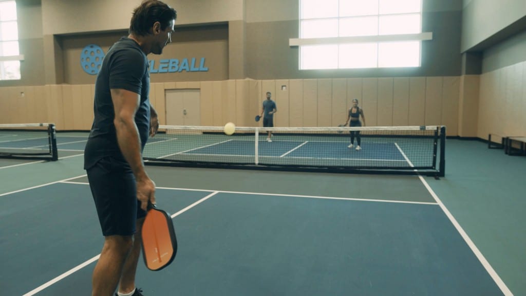 two men and a woman playing pickleball at Life Time Tennis
