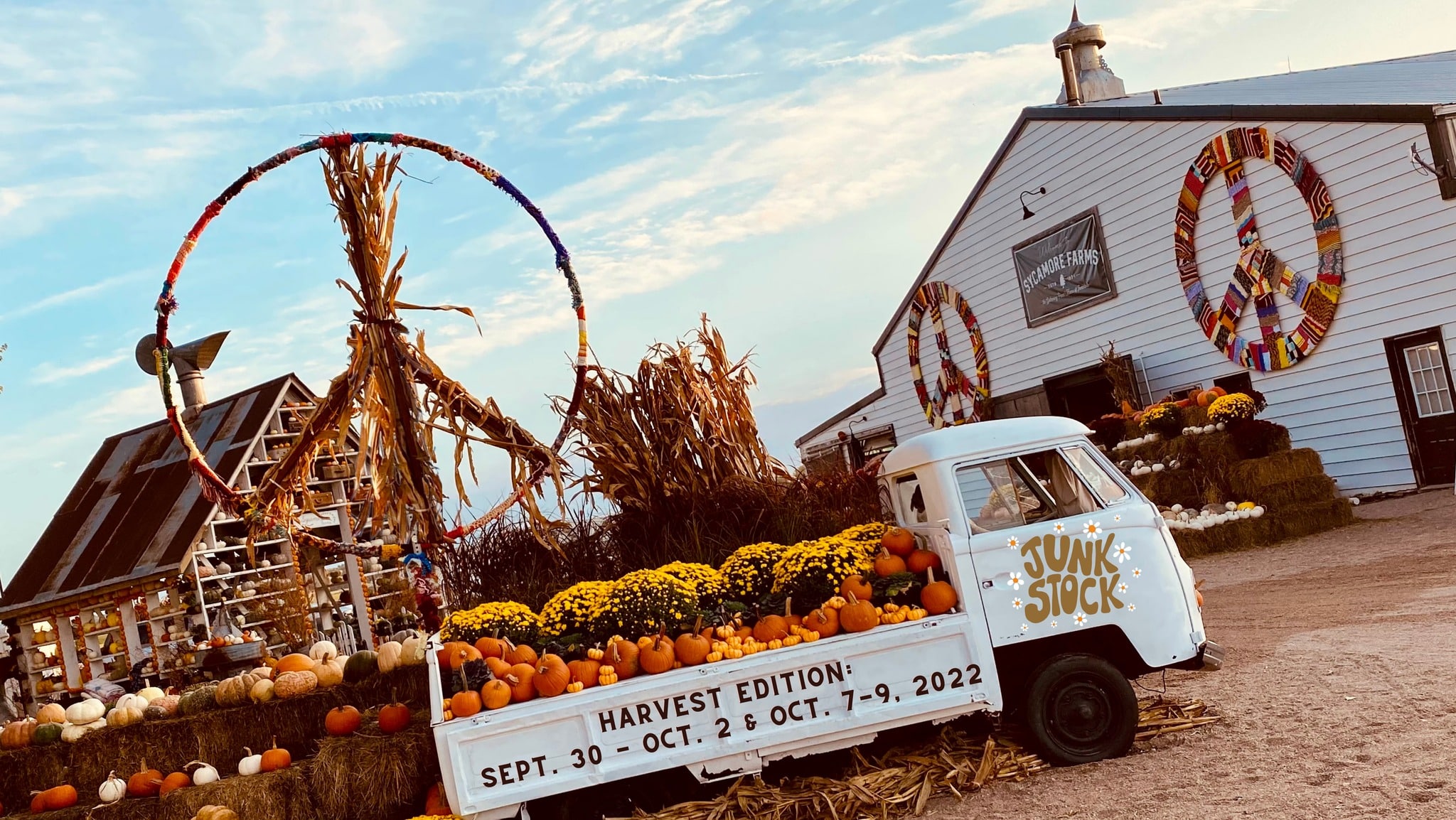 Sycamore Farms barn and pumpkin structure in the background with retro truck full of pumpkins in the foreground. 