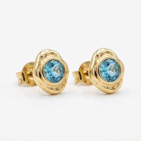 Zahiya 18K gold molten organic stud earrings with round sea-blue aquamarine gemstones on a white background