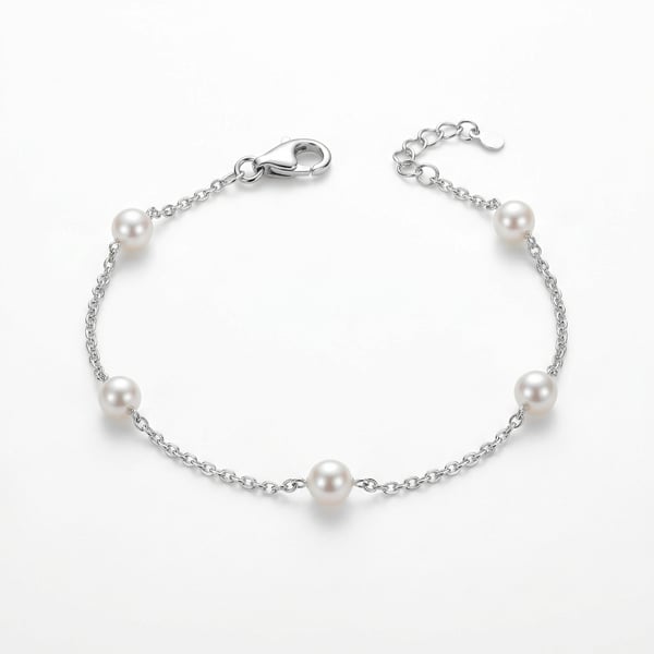 925 sterling silver chain bracelet with five station-set round white pearls on a plain white surface