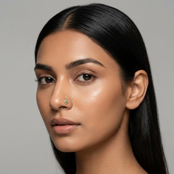 Close-up of a female model wearing the Rayan 18K gold emerald Arabic calligraphy nose pin.
