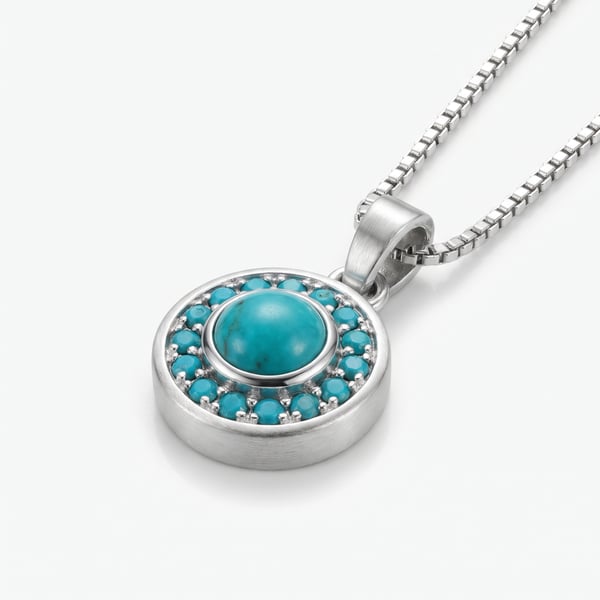 Studio macro shot of the Mansour sterling silver pendant featuring a central turquoise cabochon with a pavé halo on a white background.