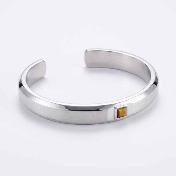 An 8mm sterling silver geometric open cuff bracelet with a flush-set square tiger eye stone on a white background.