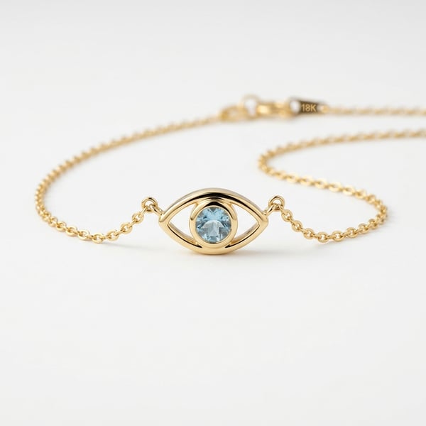 18K gold evil eye pendant necklace with a round central aquamarine stone on a plain white studio background