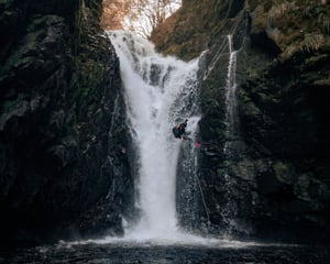 Canyoning guide descends stunning waterfall at the birks of aberfeldy in scotland