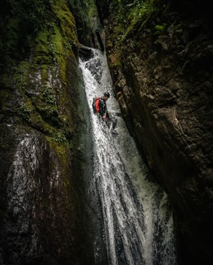 Guide abseils down waterfall at falls of bruar canyon in scotland uk