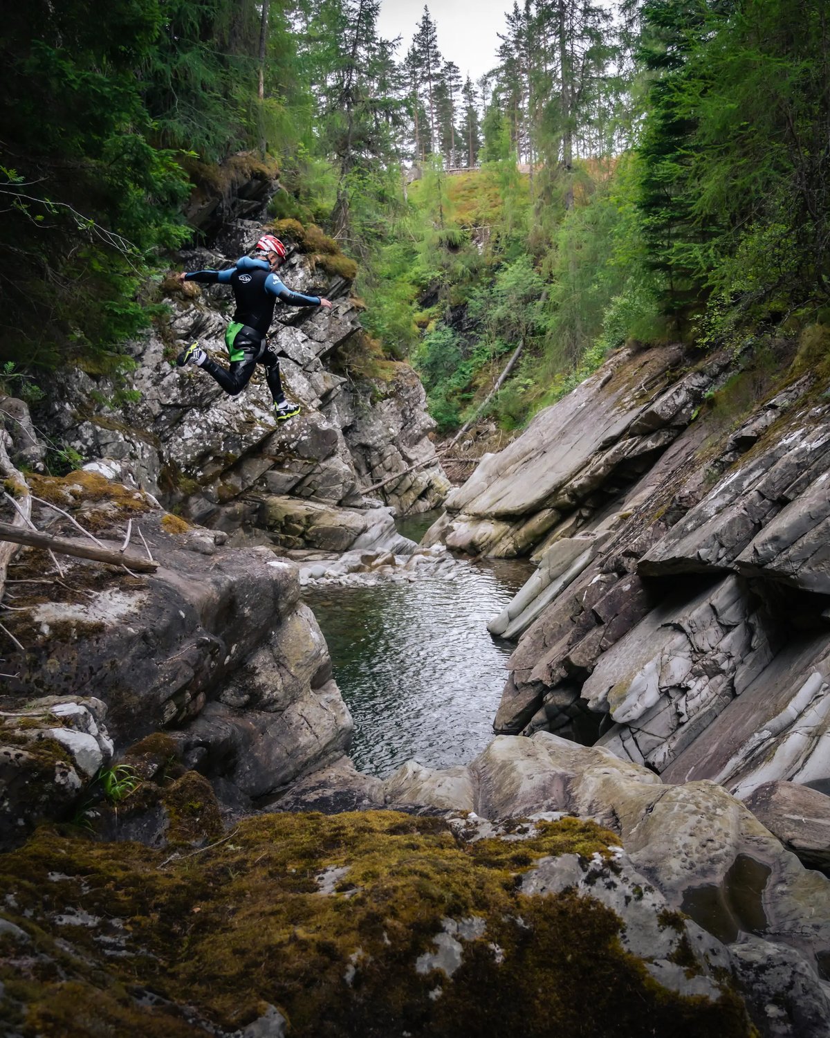 Canyoning guest jumps into a wild swimming pool on a canyoning adventure in Scotland