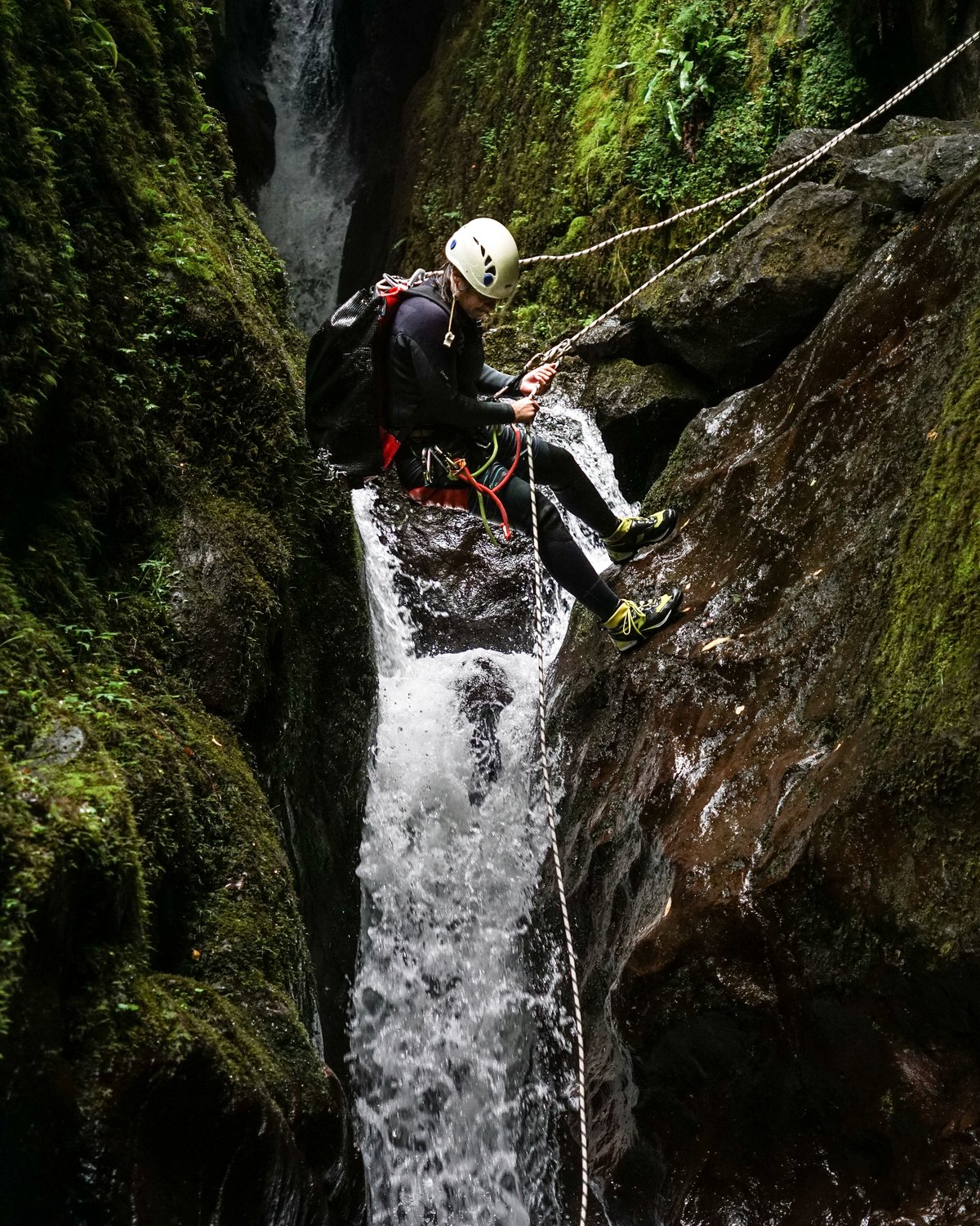 Canyoning guest jumps into an ancient glen on a sustainable adventure experience in Scotland