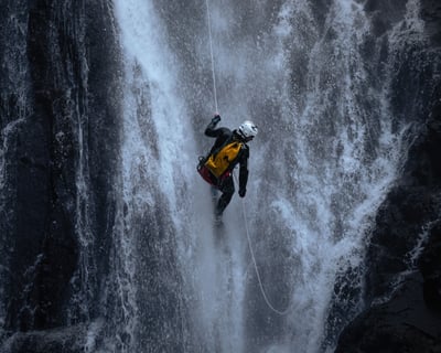 Canyoning guide jumps into falls of bruar on private canyoning adventure in perthshire scotland uk
