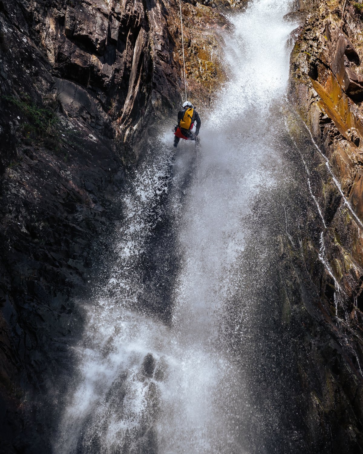 Guide decends the Epic gGrey Mare's Waterfall in Scotland on a canyoning adventure