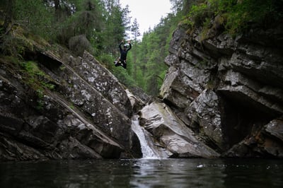 Canyoning guide jumps into falls of bruar on private canyoning adventure in perthshire scotland uk