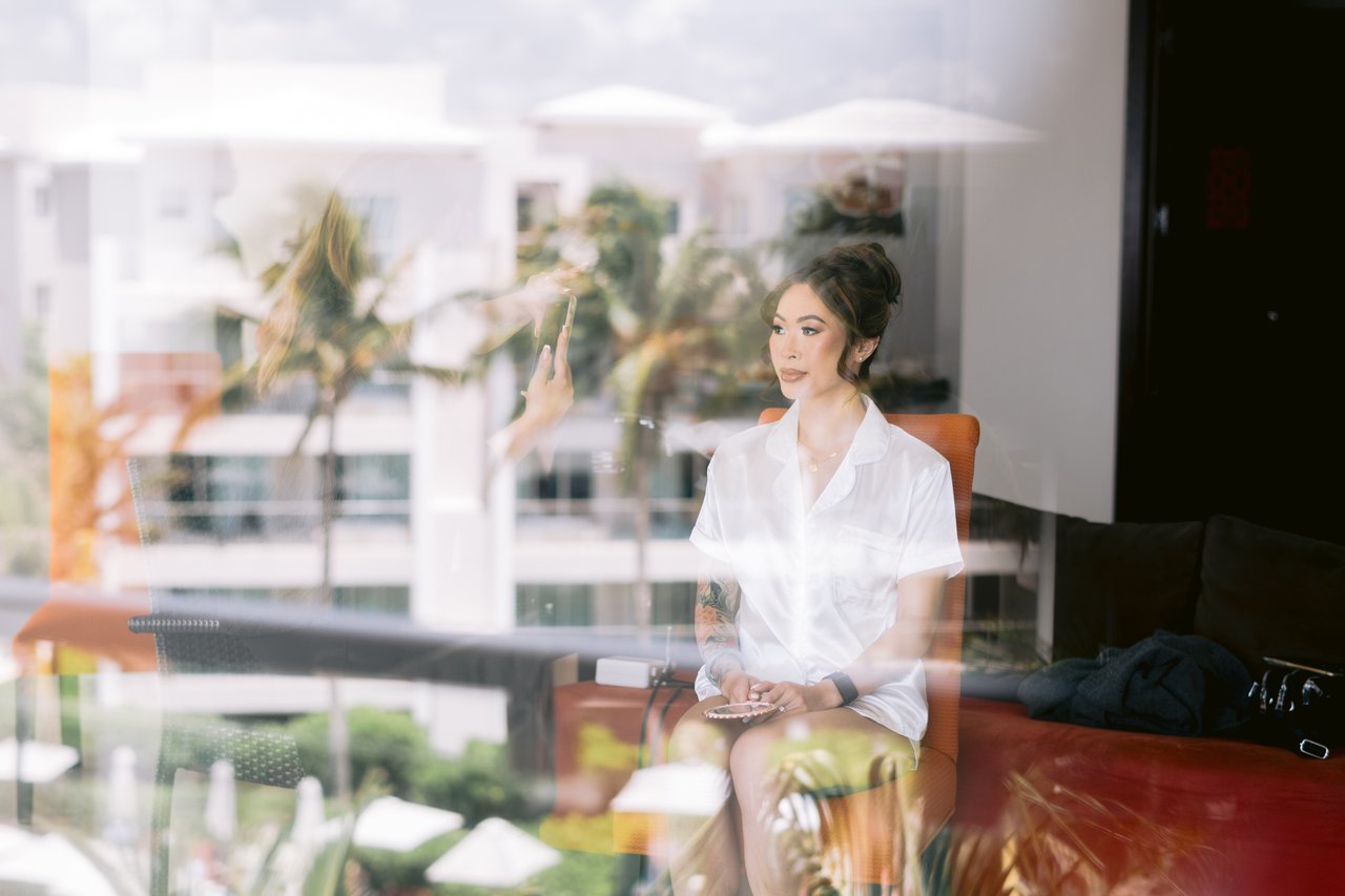 Iris in the suite window, the resort palms reflected in the glass