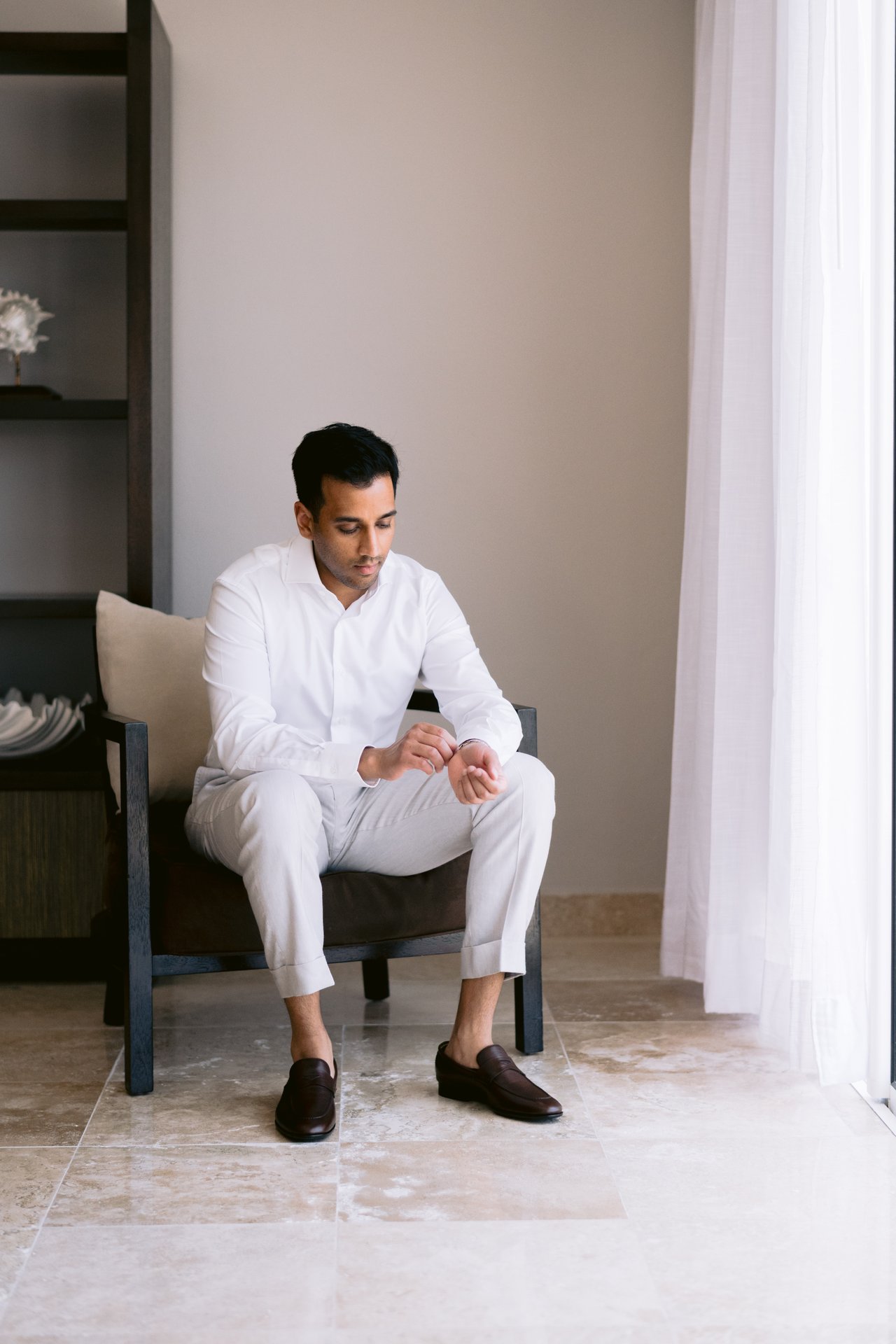 Hussain seated by the window, putting on his shoes