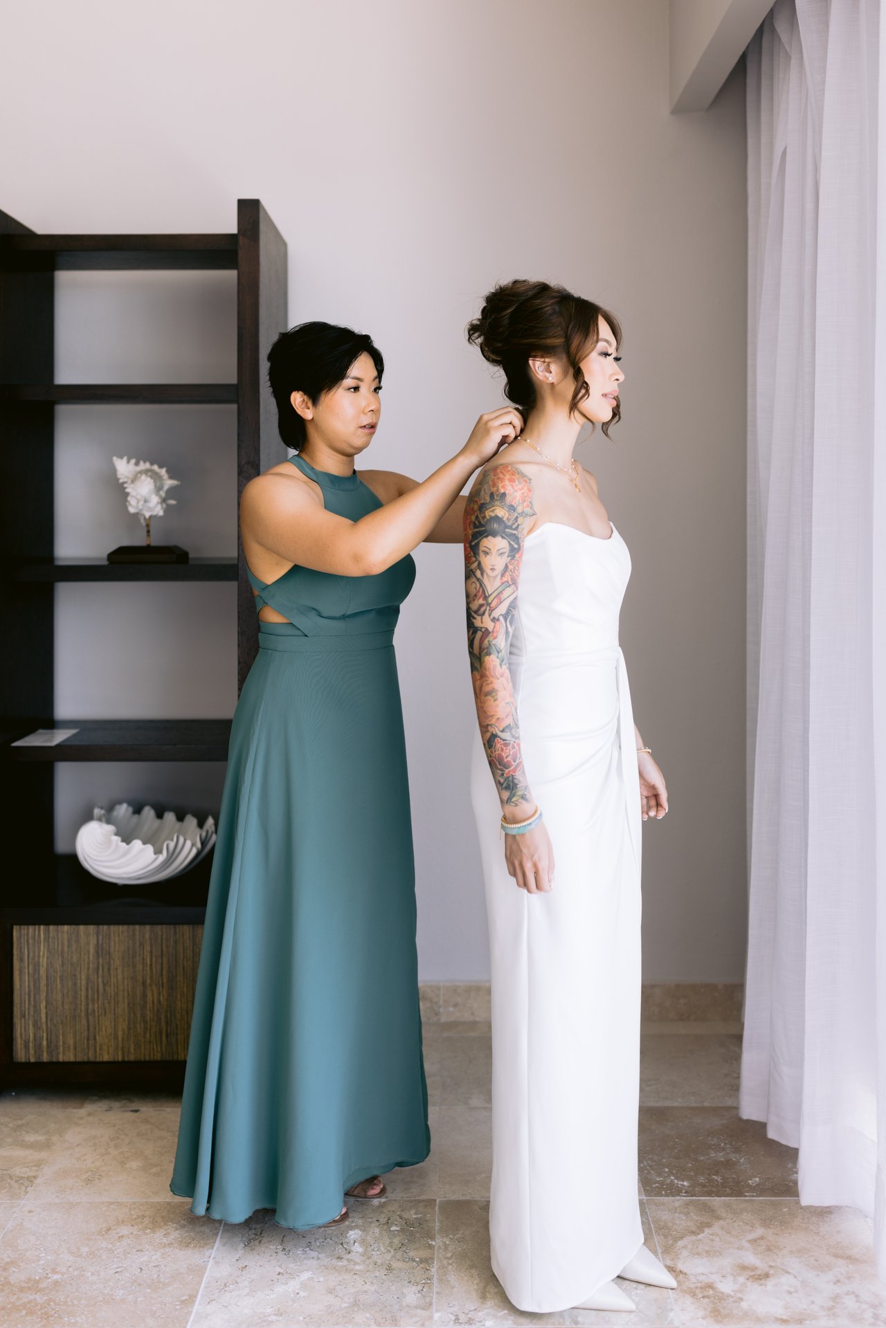 A bridesmaid fastening Iris&rsquo;s earring