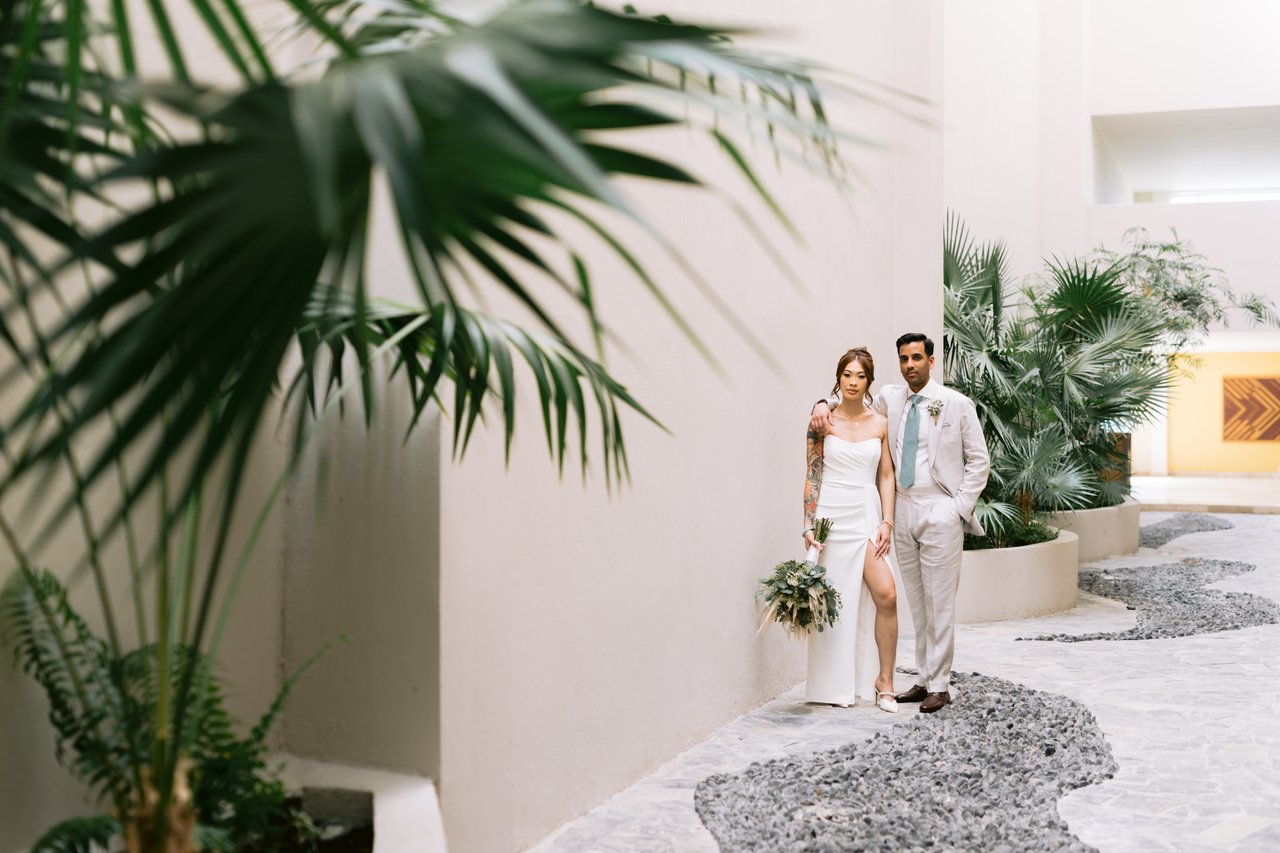 Iris and Hussain beneath a palm in the white courtyard