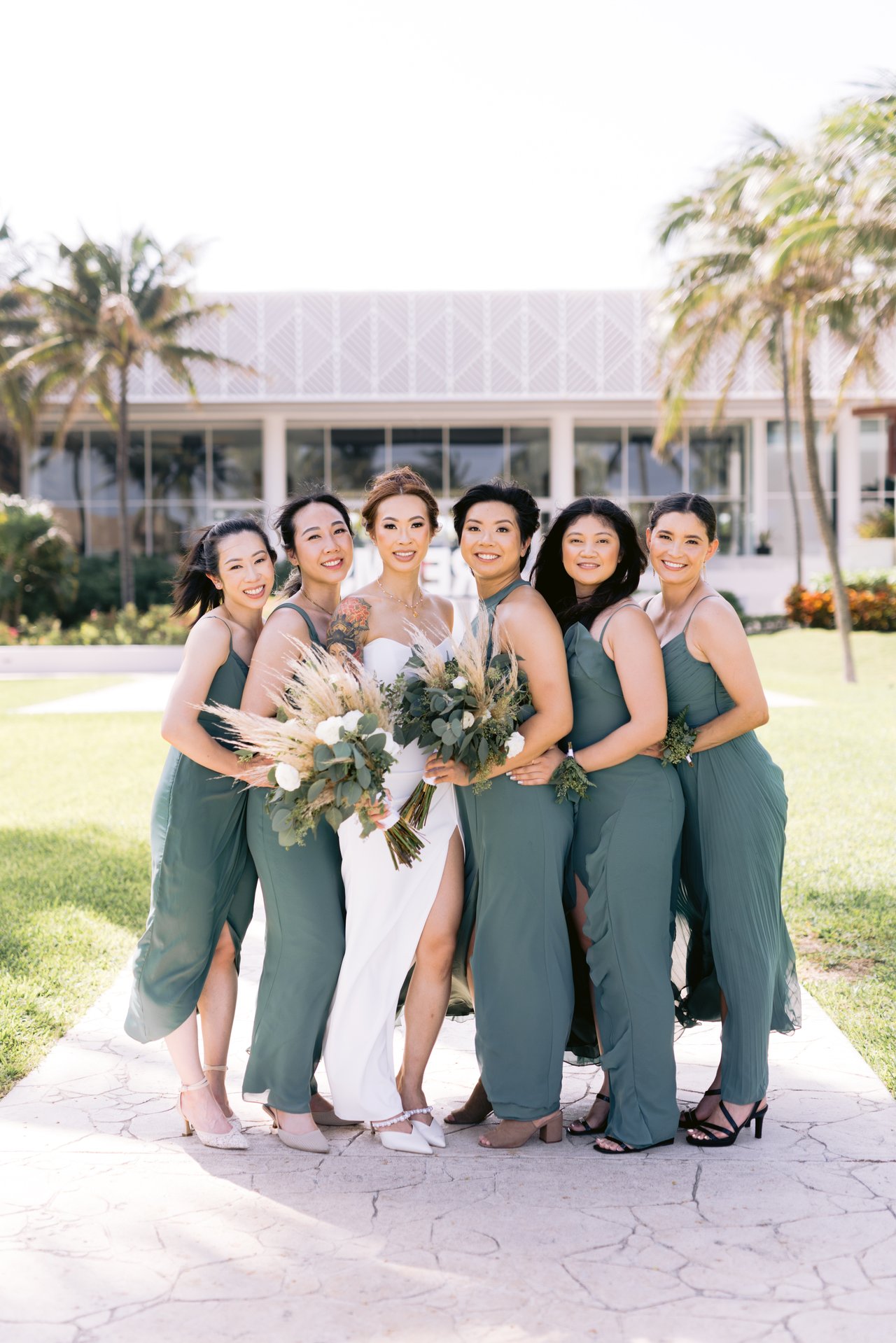 The bridesmaids in sage green with their bouquets