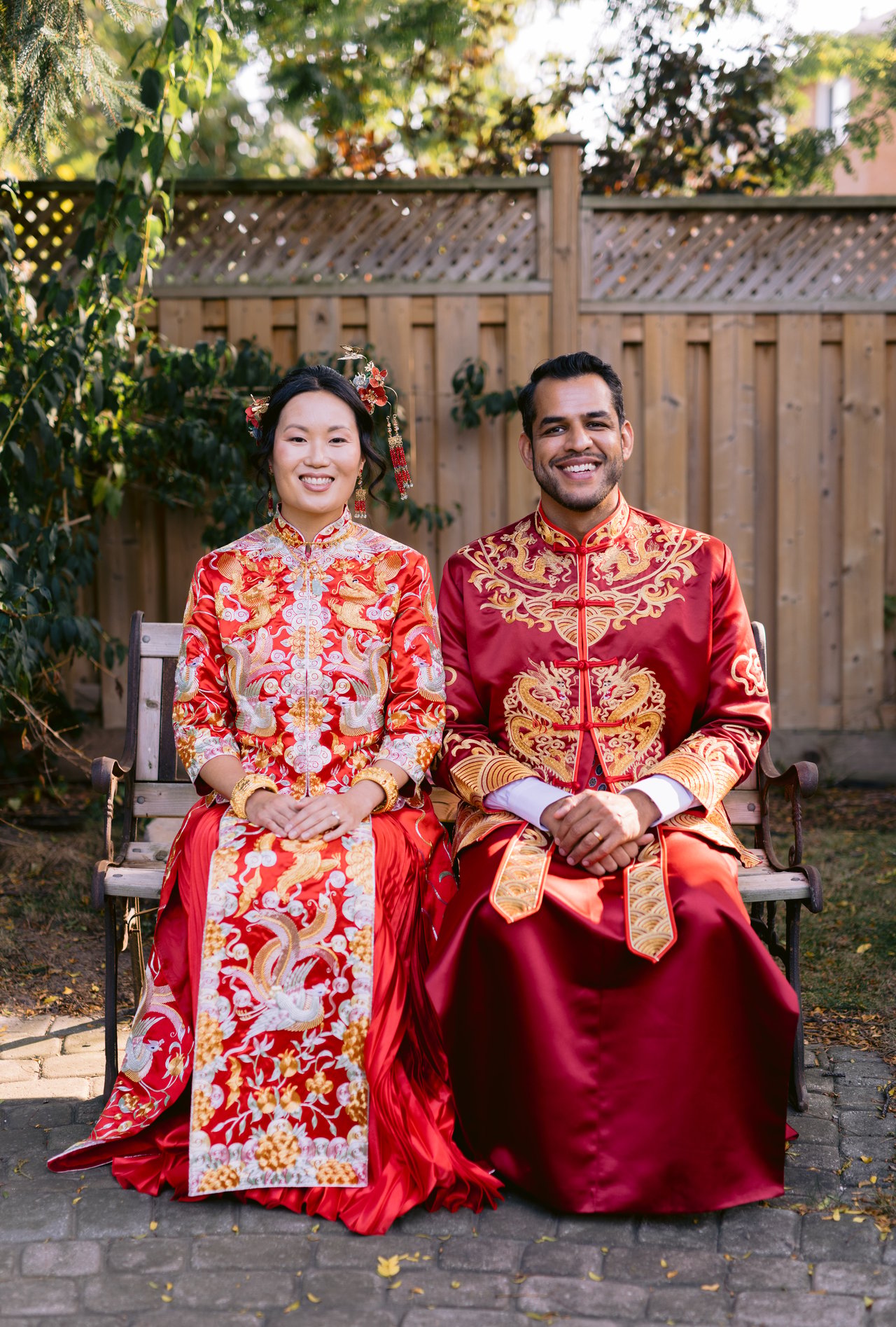 Vicky and Saurabh in traditional red Chinese wedding attire, seated together