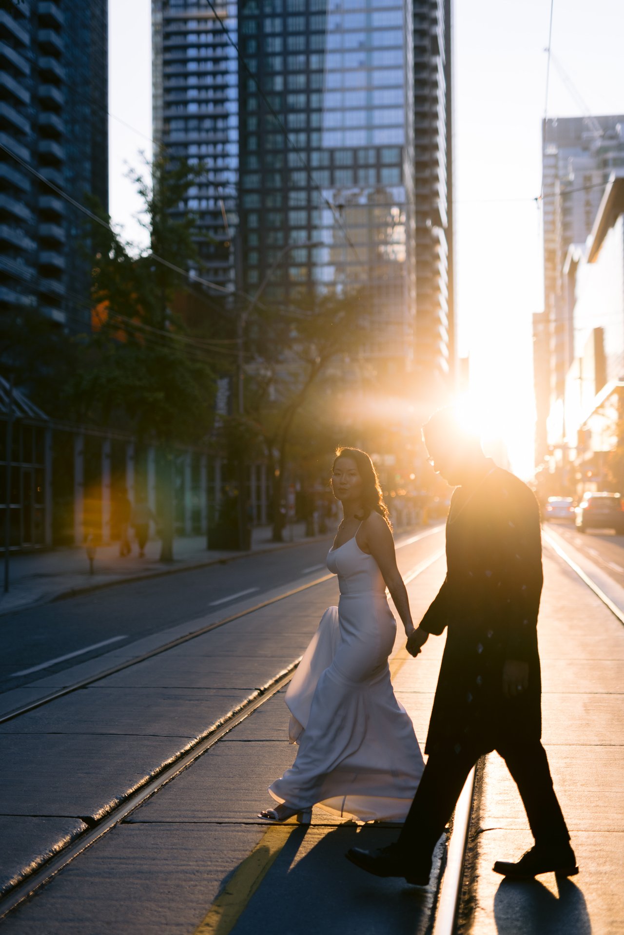 Vicky and Saurabh crossing a downtown street in the golden evening light