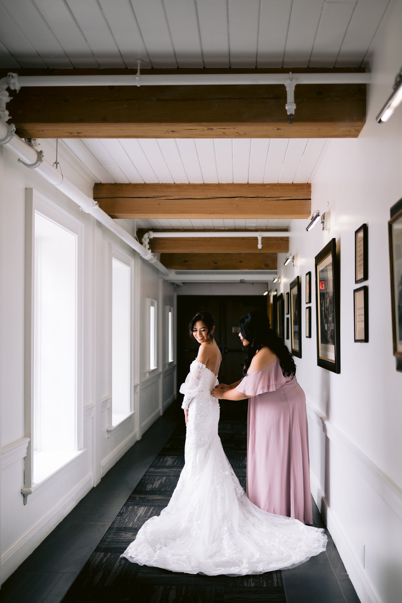 A bridesmaid lacing Kat into her gown