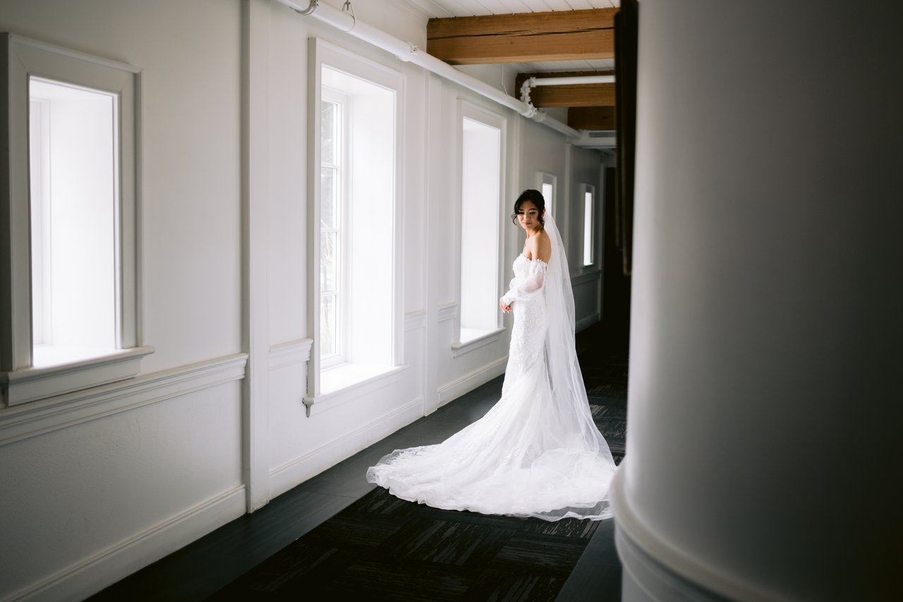 Walking the length of the hall, the train behind her