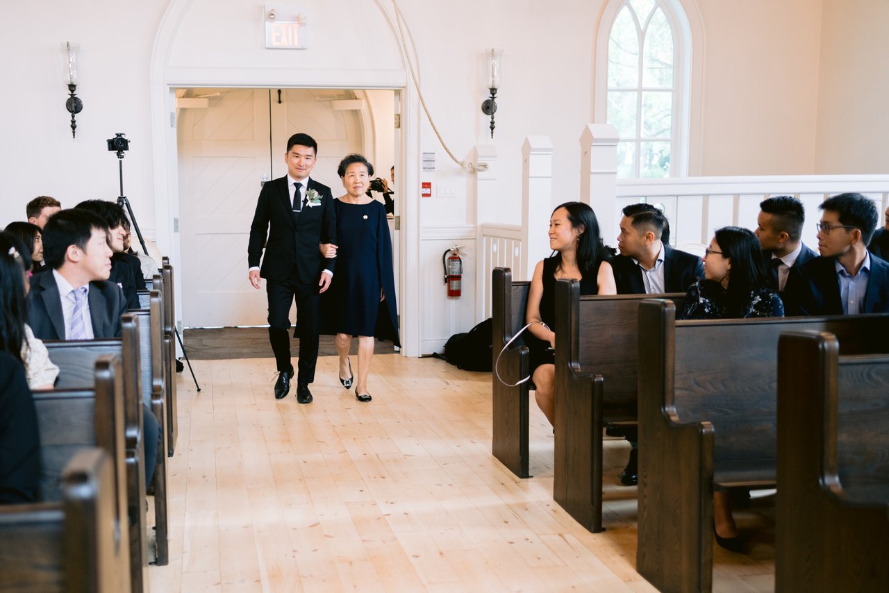 The aisle, dark beams and chandeliers overhead