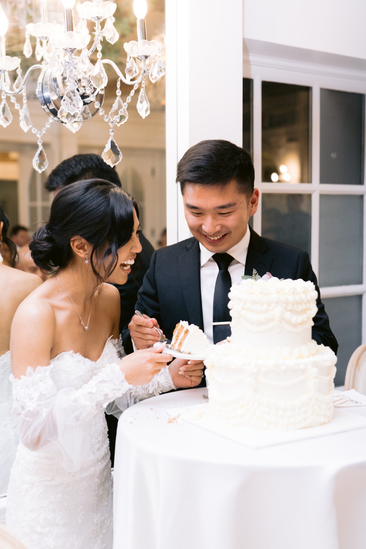 Cutting the cake under the chandelier