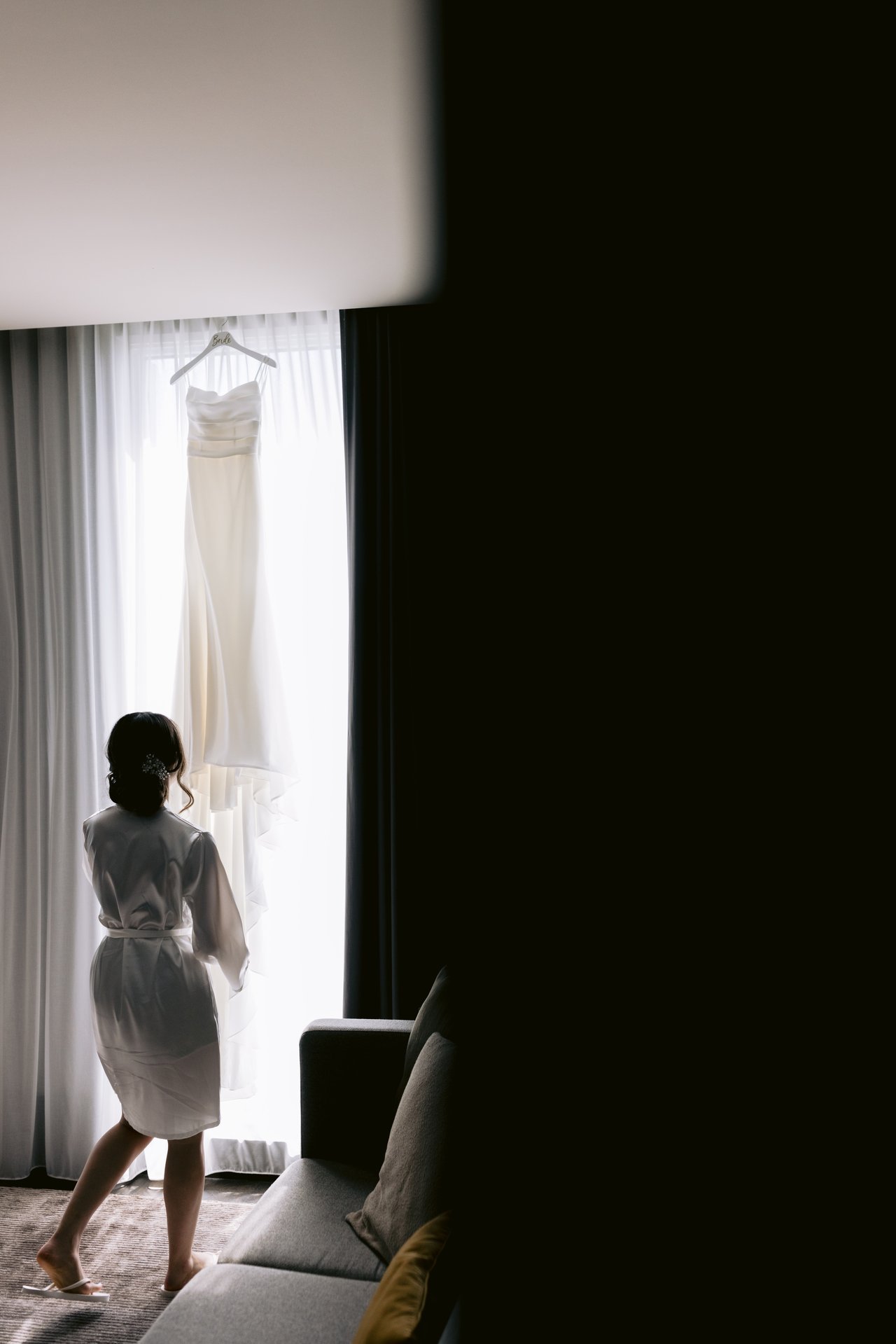 Katie at the window in her robe, the dress beside her