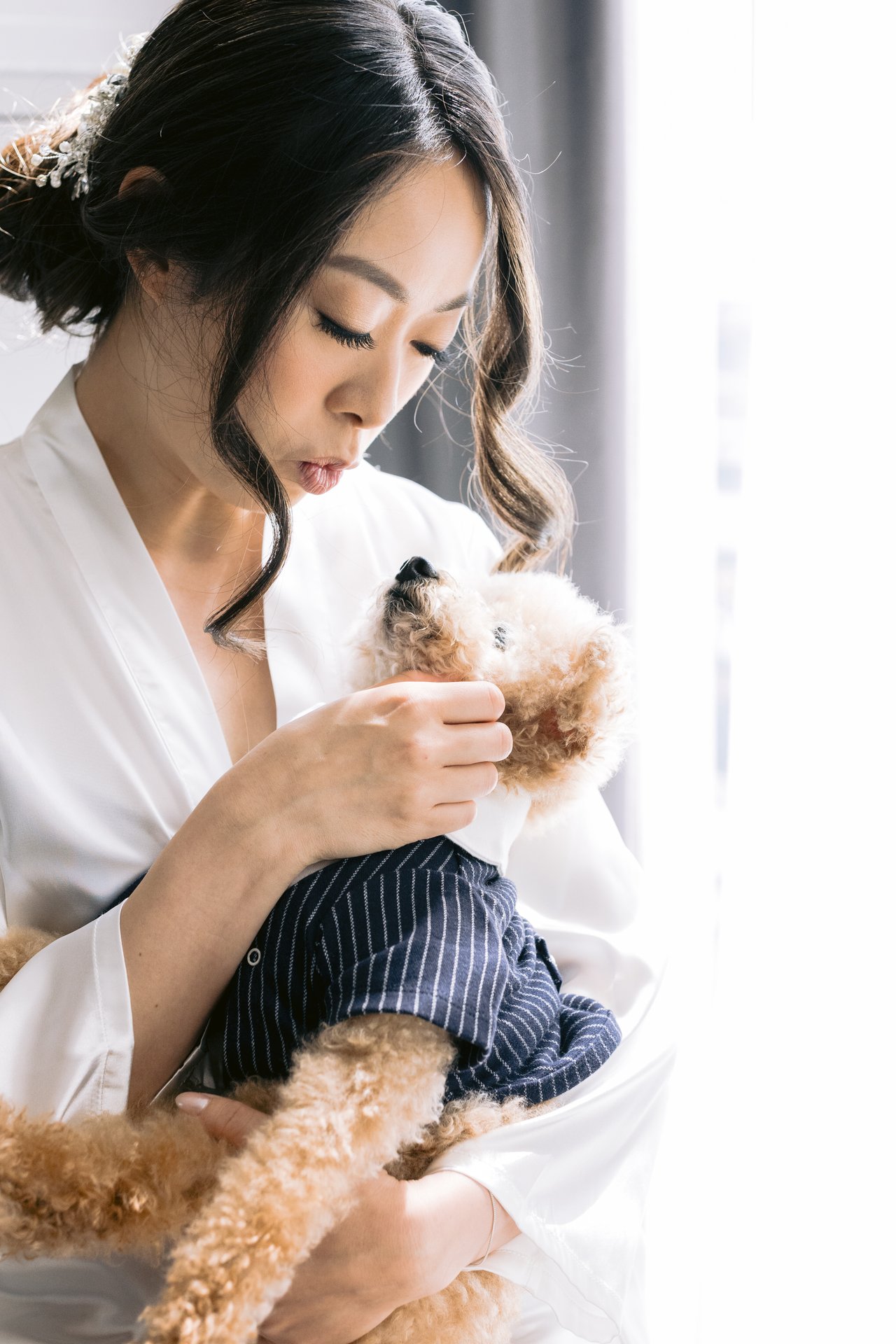 Katie in her robe holding their small dog