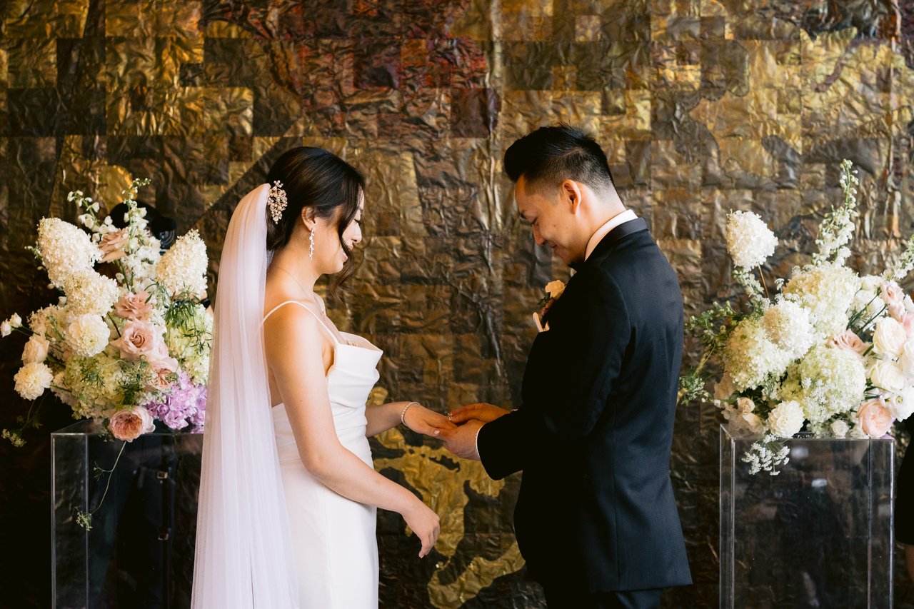 The couple at the altar, florals in the foreground