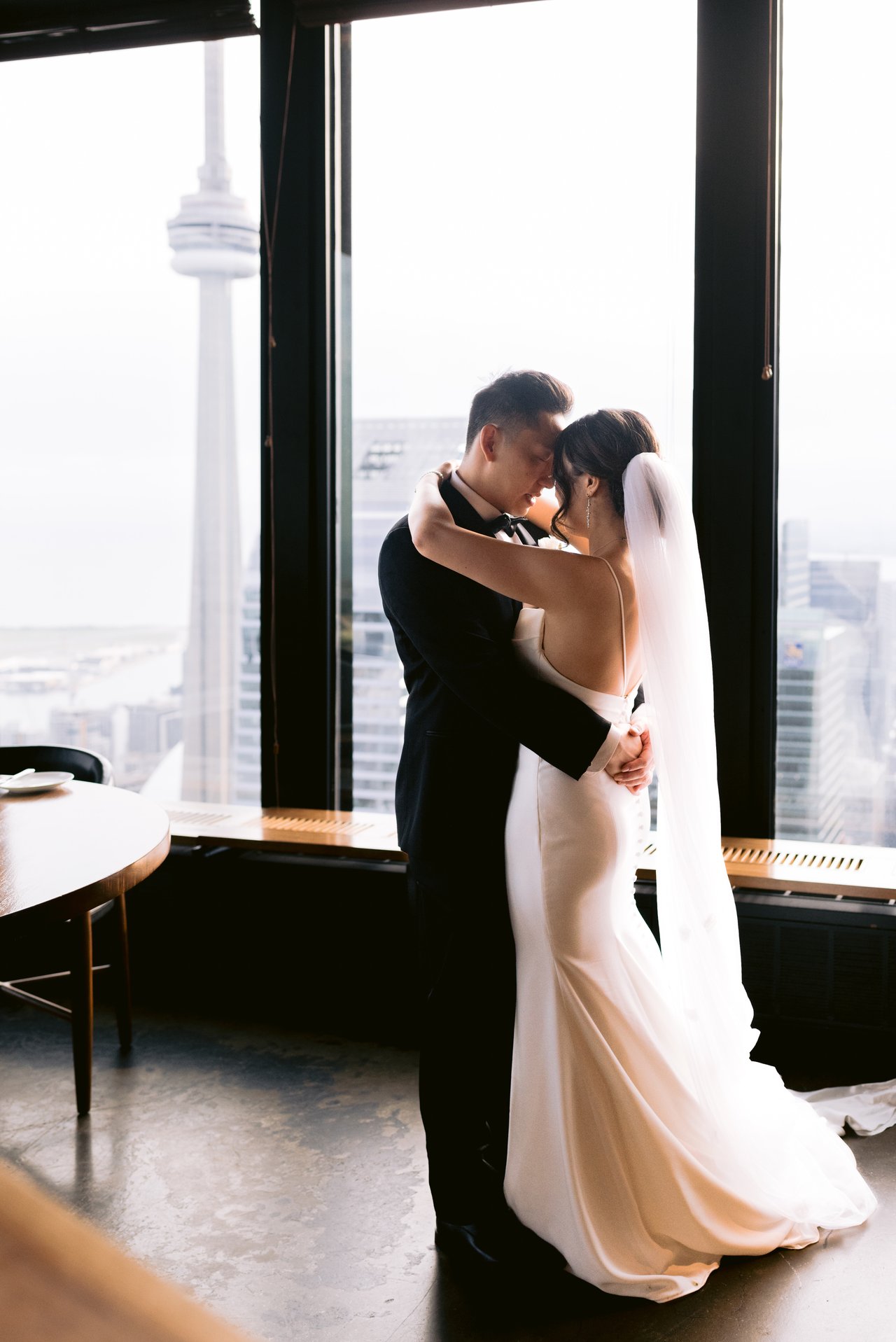 Katie and Harry by the window, the city behind them