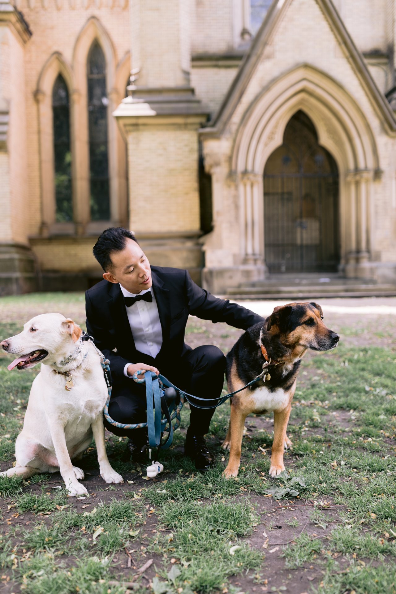 Holding the leashes, the dogs at his side
