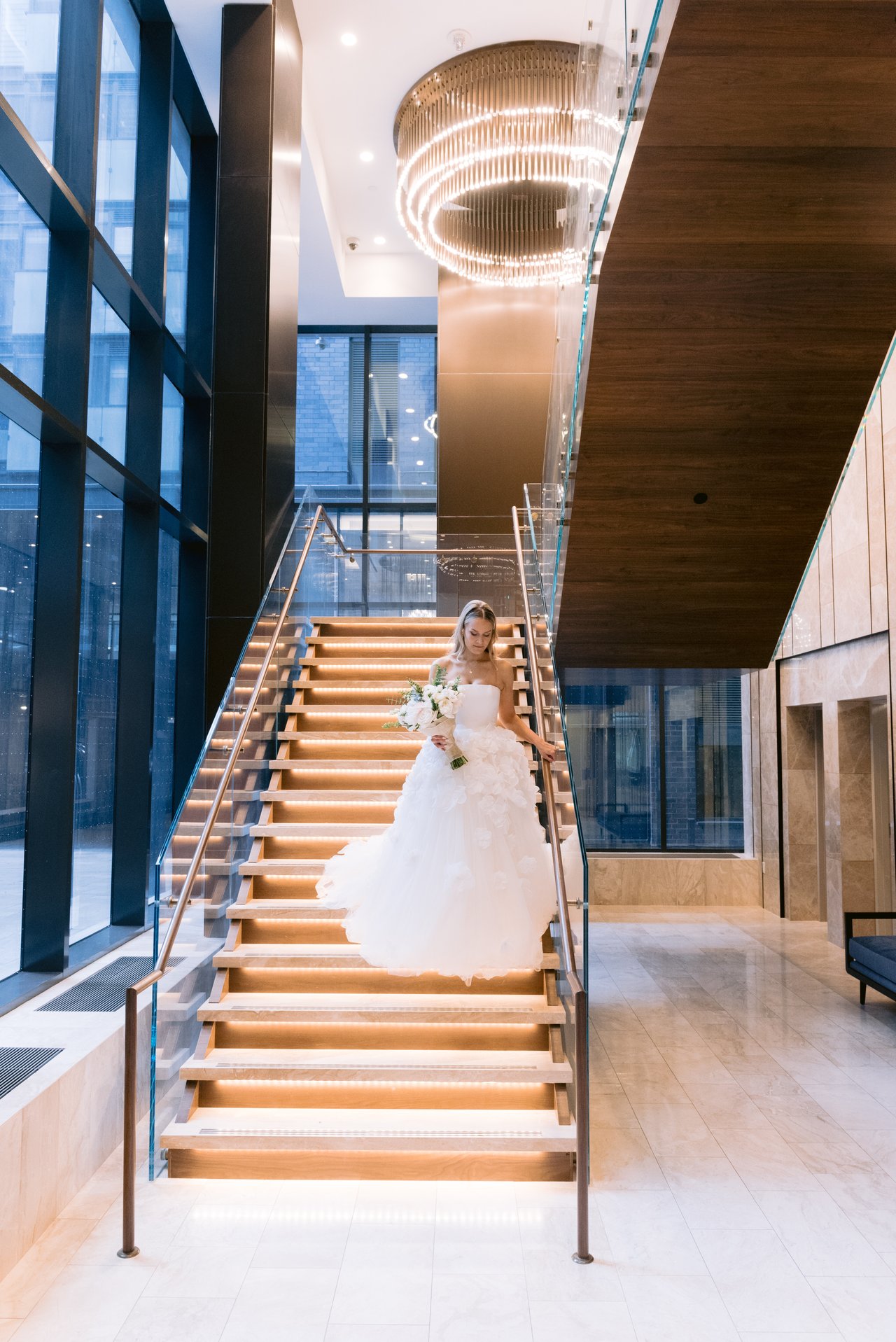Magda in the gown, under the round light