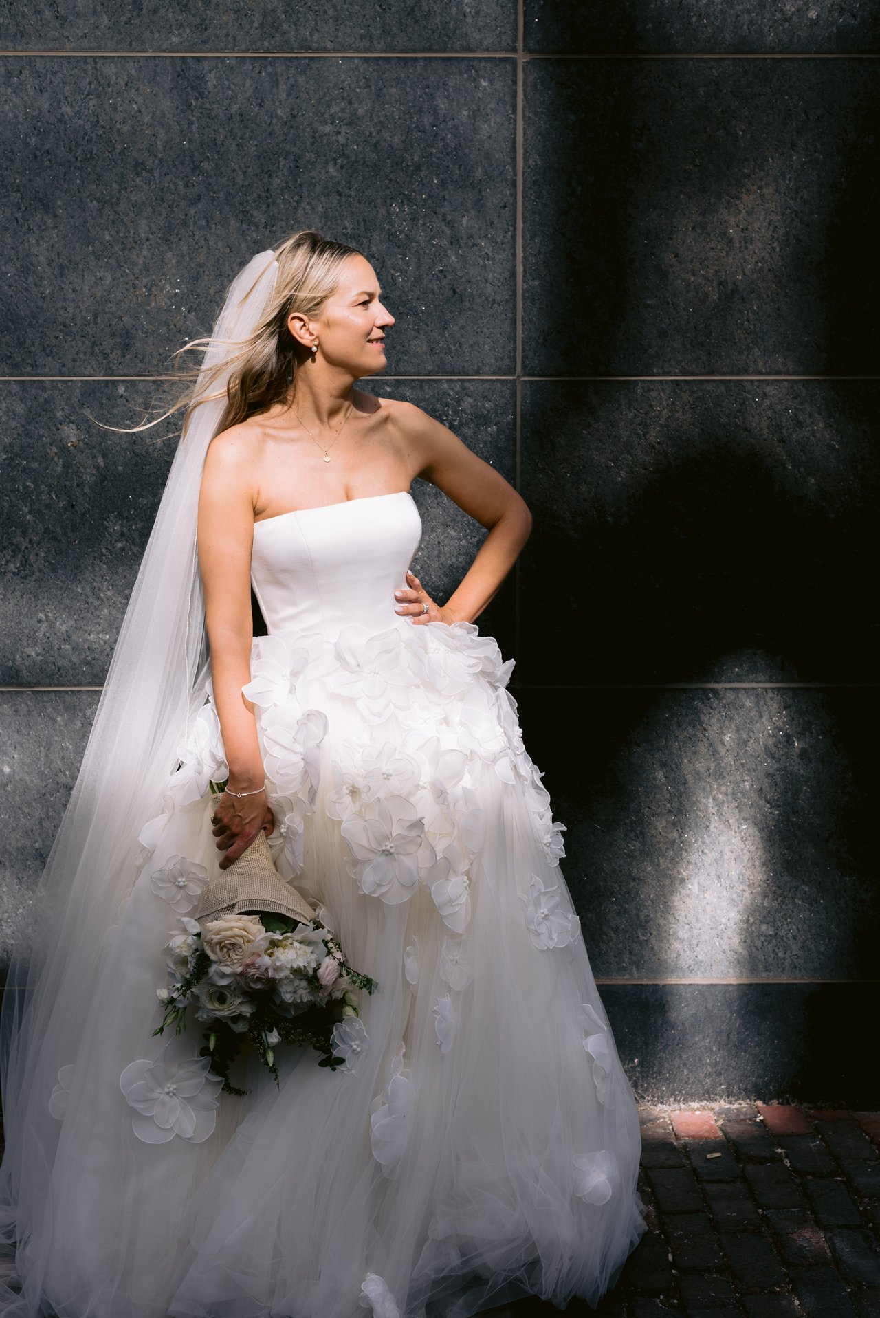 Magda in the hard light, bouquet in hand