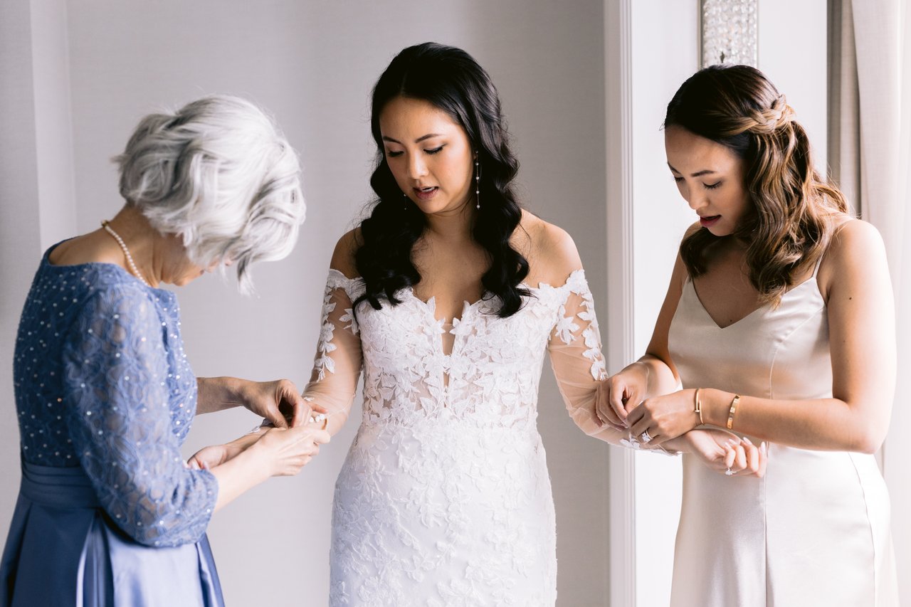Stella stepping into her gown, her mother helping