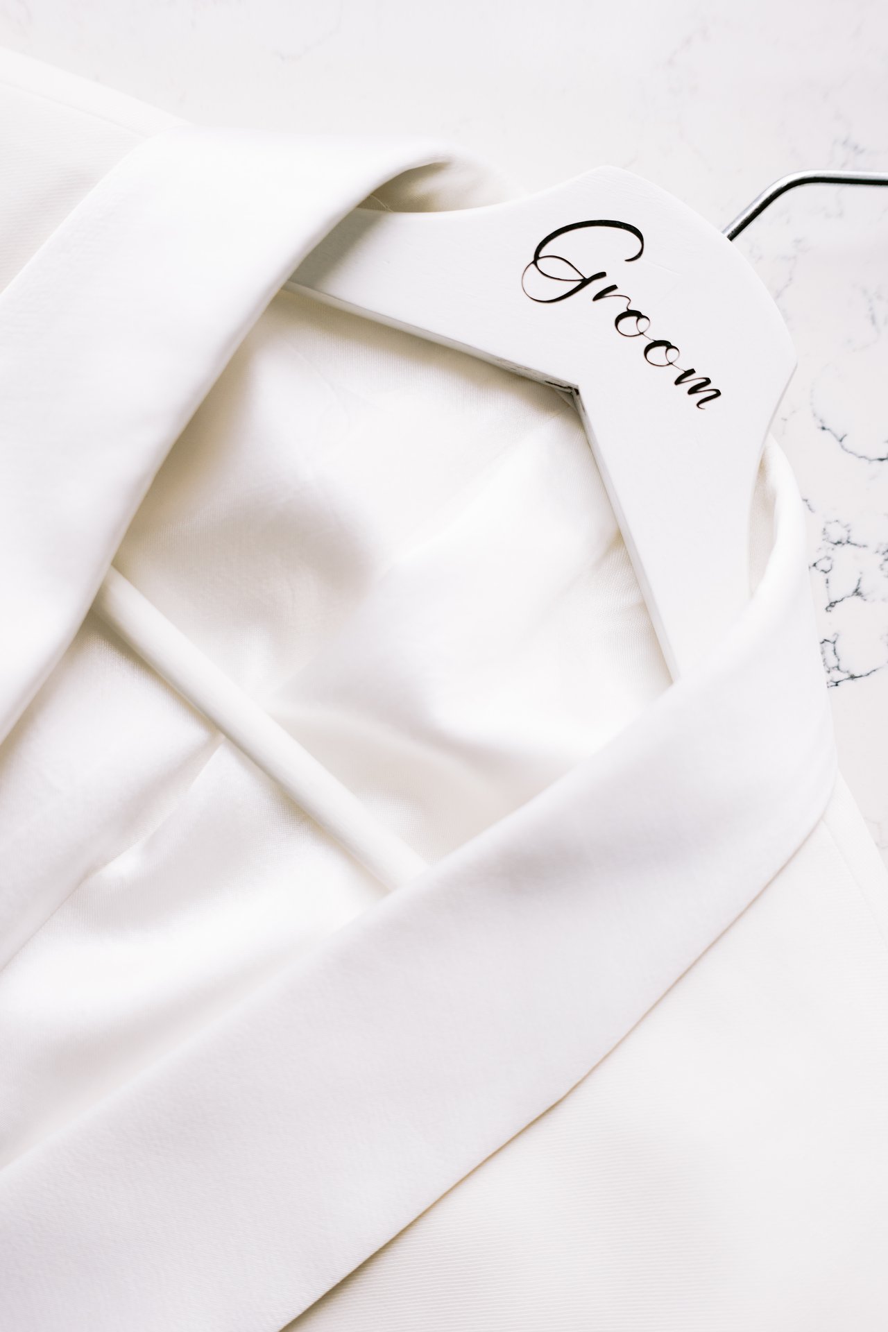 The groom&rsquo;s jacket on its hanger