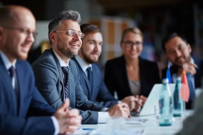 Business meeting with men and woman in suits smiling happy
