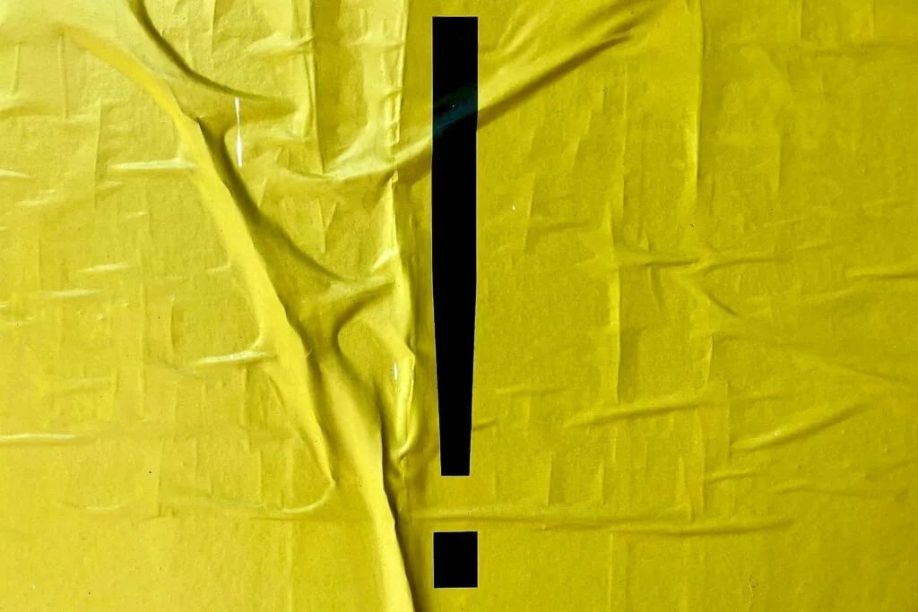 Un fondo amarillo arrugado con un signo de exclamación en el centro.