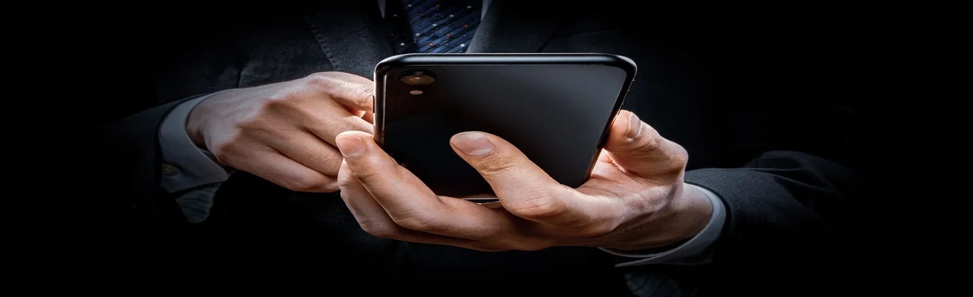 man holding mobile phone wearing business attire