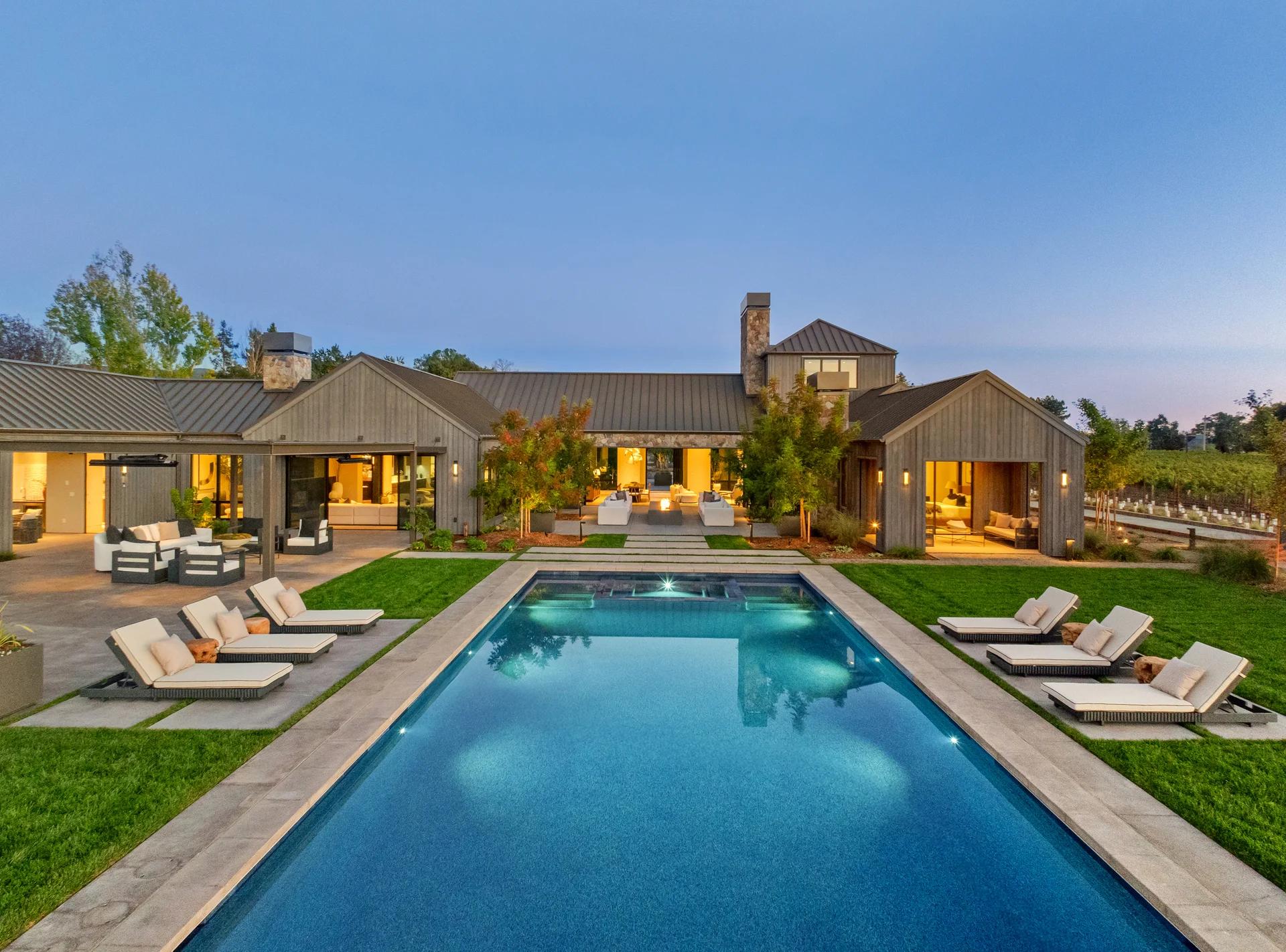 Contemporary home and pool illuminated at dusk