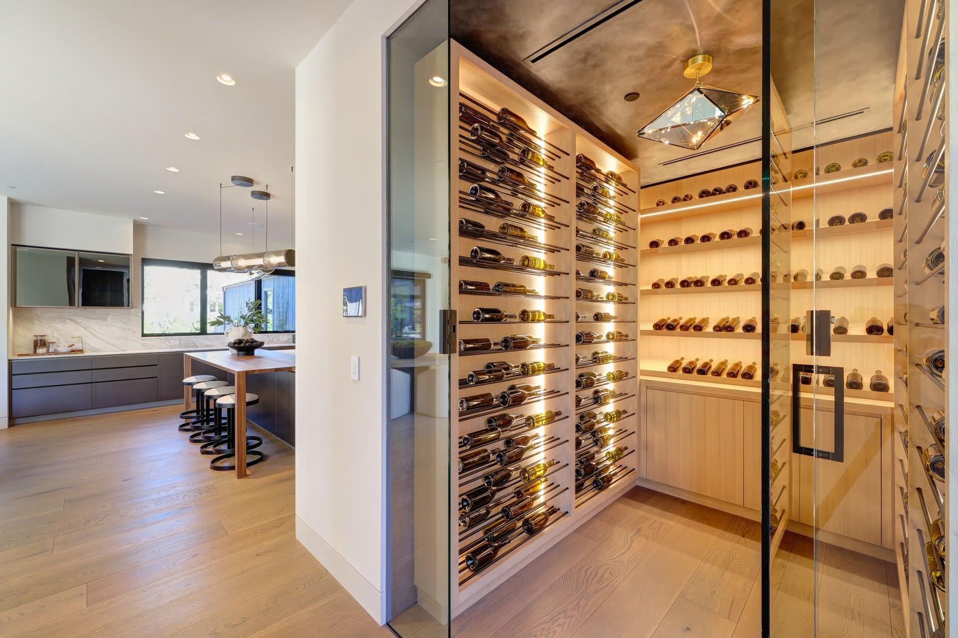 Glass-enclosed wine cellar beside a modern kitchen