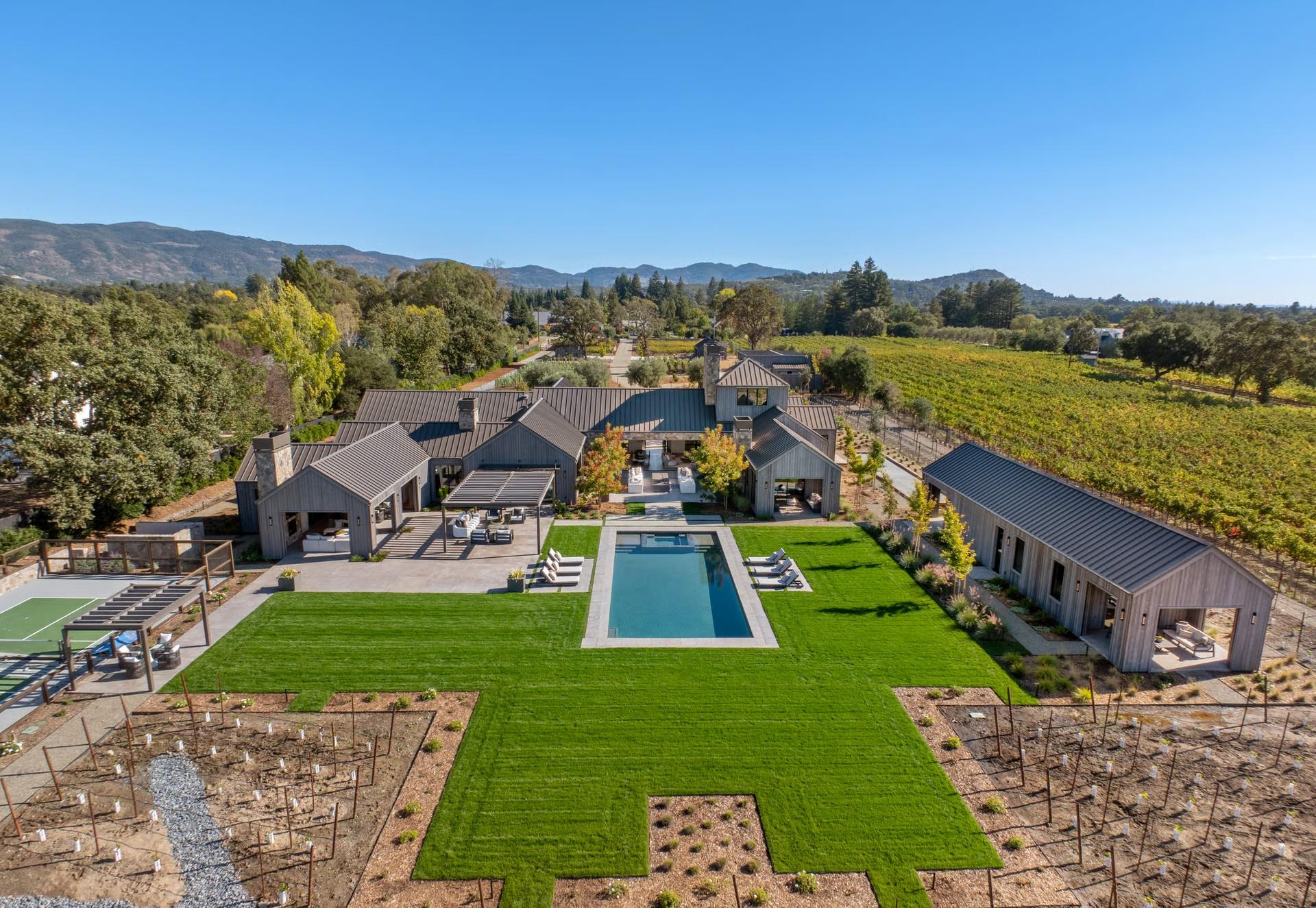 Aerial view of a contemporary estate bordered by vineyard rows