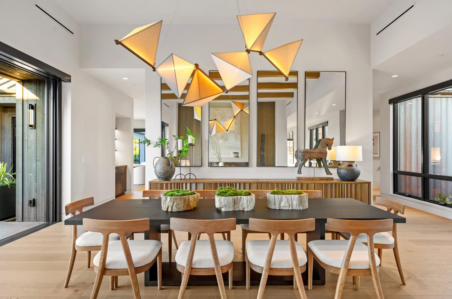 Dining room with a long wood table and sculptural pendant lights