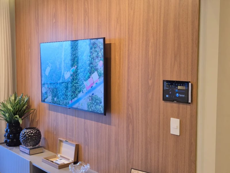 Painel de controle iConnect na parede ao lado da TV