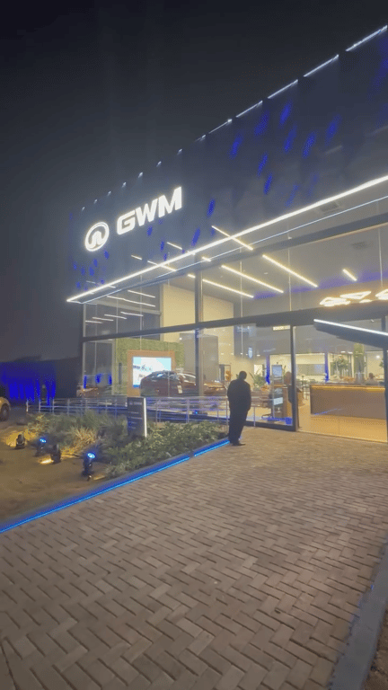 Fachada noturna iluminada da concessionária GWM em Campo Grande/MS