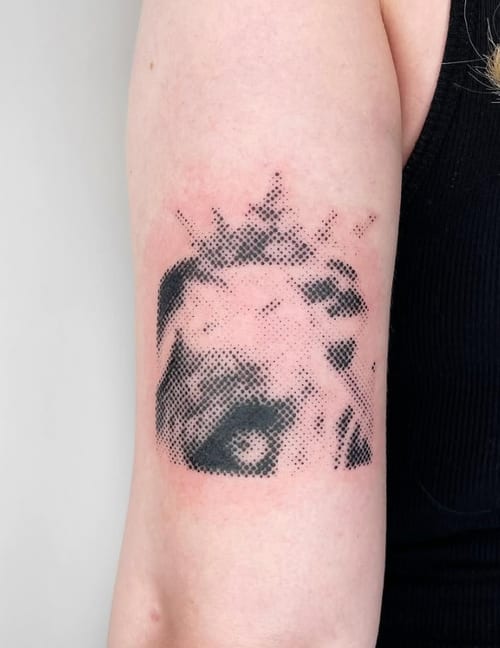 An abstract dotwork tattoo of an eye on the upper arm, using black ink with a stippling effect — by Level tattoo, los angeles